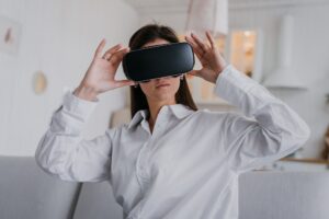 Beautiful young girl in virtual reality headset. Augmented Reality. Happy woman holds 3D vr glasses
