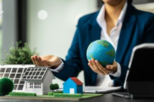 A businesswoman is reviewing contract papers at her desk in a sustainable house and condo