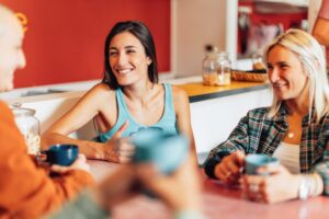 friends in a co-living space relaxing with a cup of coffee and chatting together