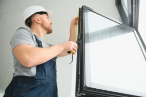 Construction worker installing window in house