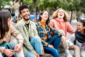 Millenial friends sitting together at city place on life style concept
