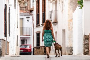 young woman walking down the street with boxer dog