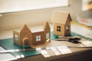 houses cut out of recycle cardboard on window during manufacturing process.