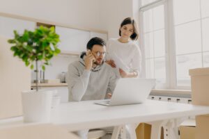 Male model searches information on laptop computer, searches new flat for rent