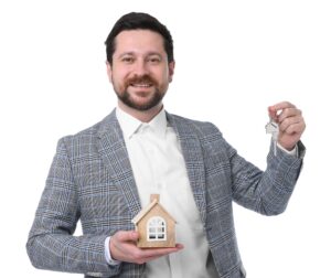 Real estate agent holding key with keychain and house model on white background