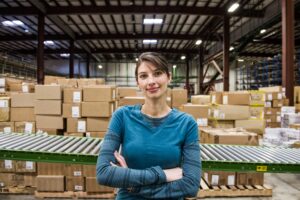 A caucasian female warehouse worker in a distribution warehouse.